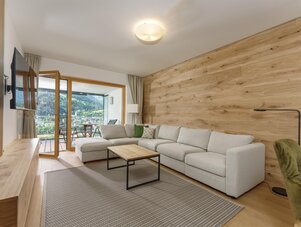 Modernes Wohnzimmer mit grauer Eckcouch und Holzwand