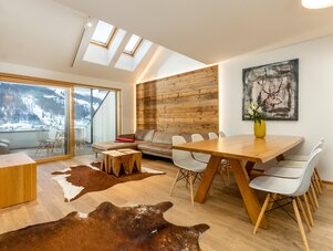 Heller offener Wohn- und Essbereich mit Holzakzenten und großen Fenstern