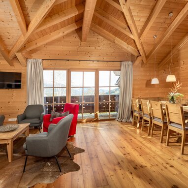 Rustikales Holz-Wohnzimmer mit Essecke und Bergblick