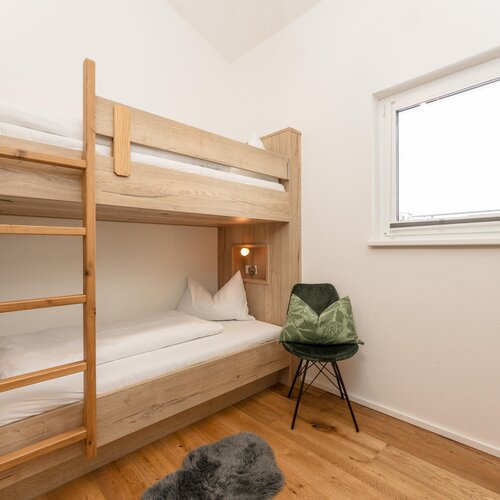 Wooden bunk beds with ladder in a bright room