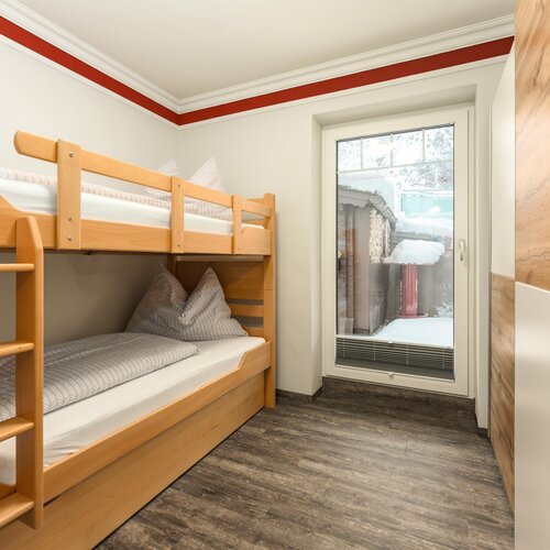 Bedroom with wooden bunk beds and a glass door