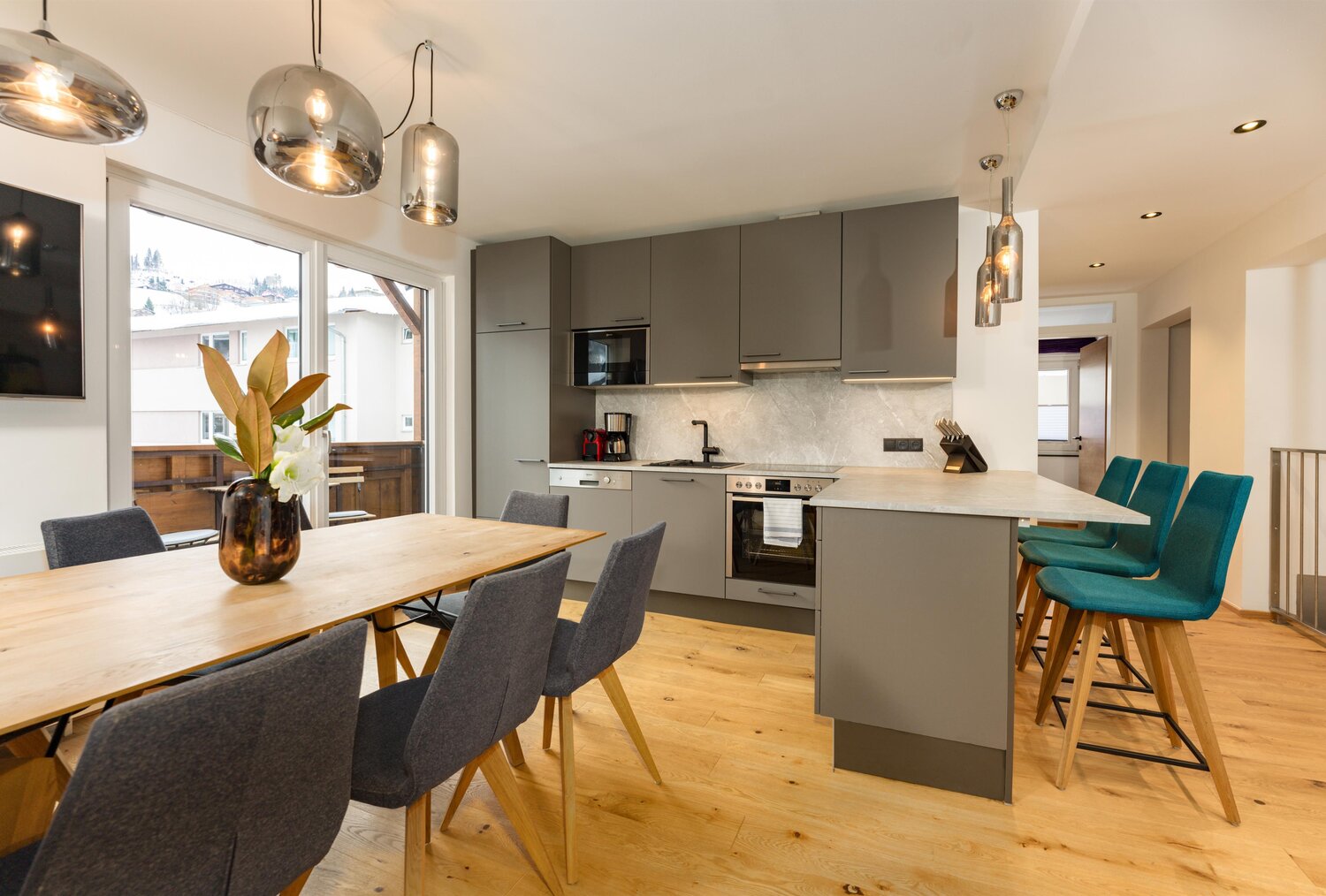 Moderne Küche mit grauen Unterschränken, Insel und Esstisch