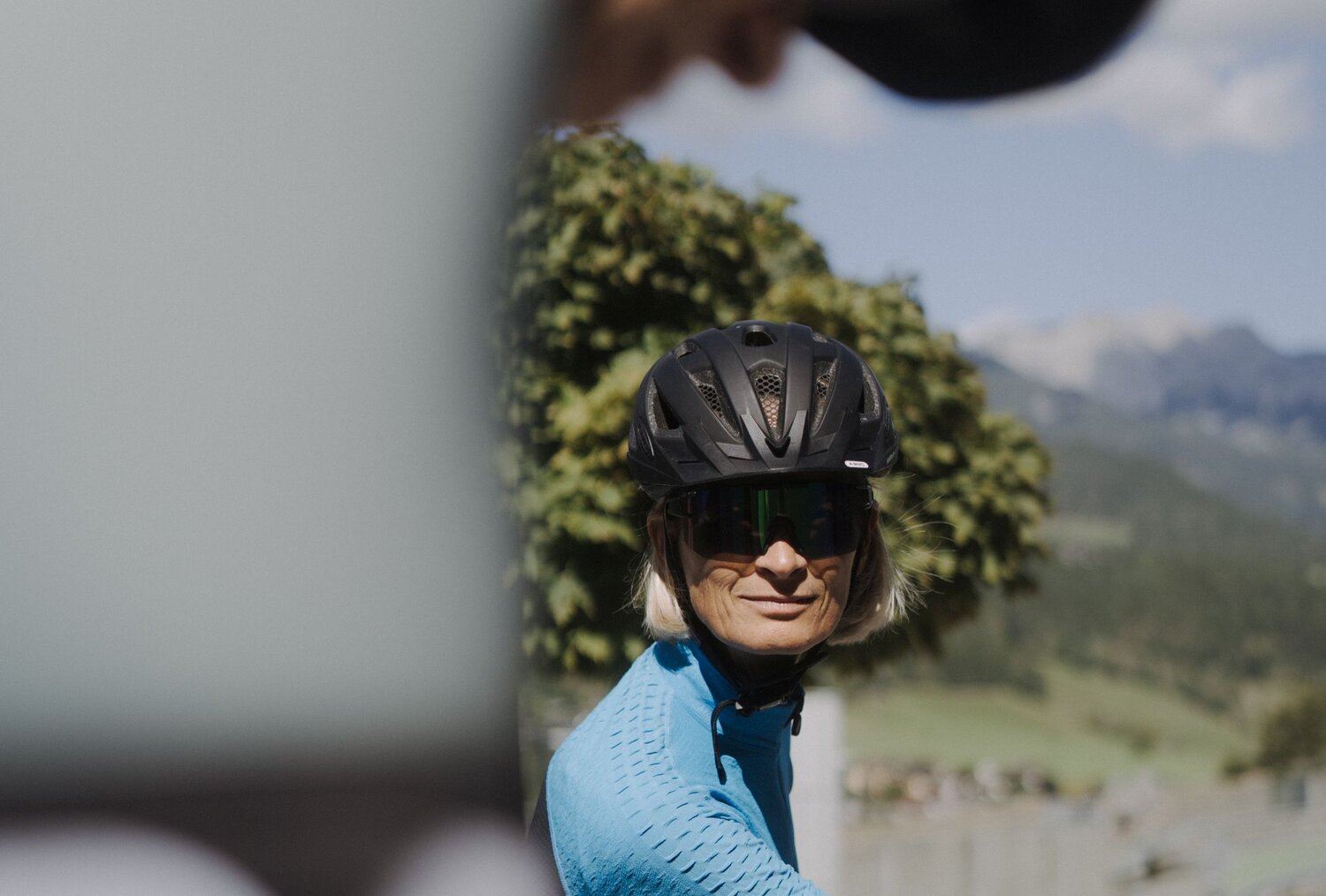 Frau Radfahrerin mit Helm und Sonnenbrille fährt draußen