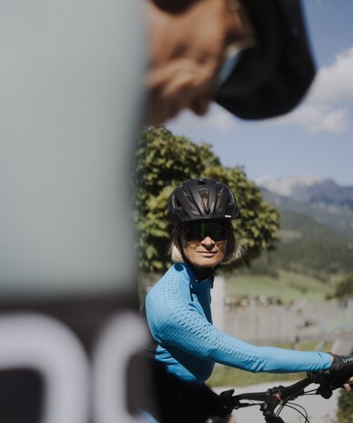 Frau Radfahrerin mit Helm und Sonnenbrille fährt draußen